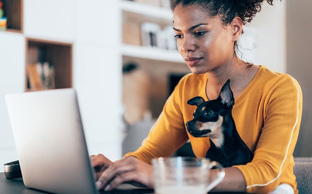 Woman on the computer with her dog. 