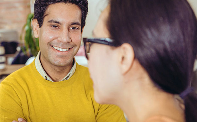 Man smiles at woman.