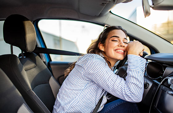 Women sitting inside a new car smiling 