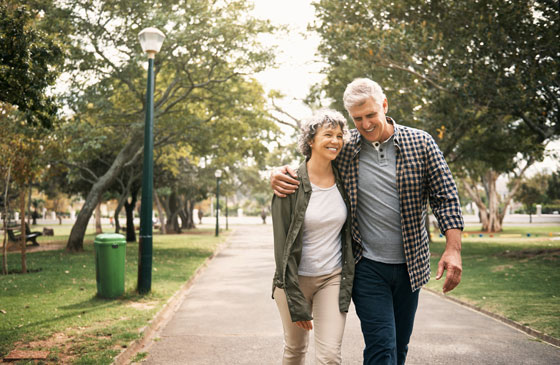 Older retired couple walking in park together