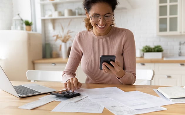 Woman on phone surrounded by forms