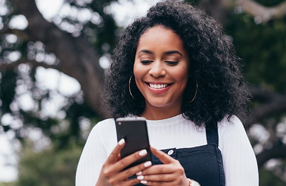 Women looking at her phone screen and smiling.