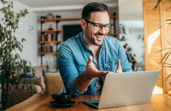 Man looking at his laptop and smiling.