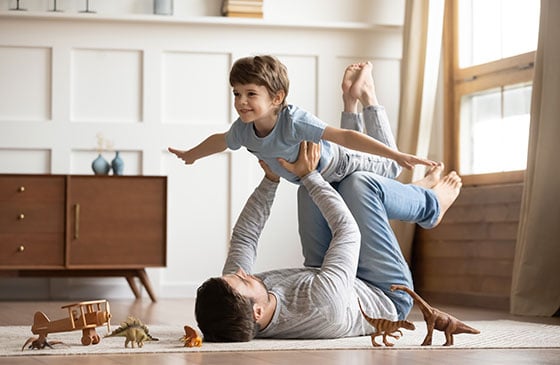 Man playing airplane with his son