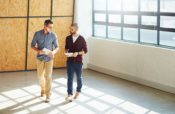 Two men walking in an empty building