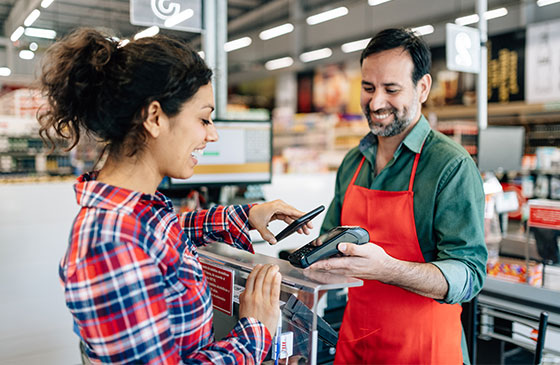 Women using smartphone to make an in-store purchase 