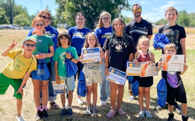 Group of adults and kids smiling outside