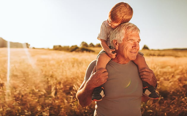 Man giving grandson piggy-back ride