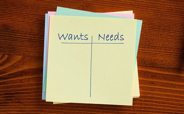 Paper with "wants vs needs" written on it.