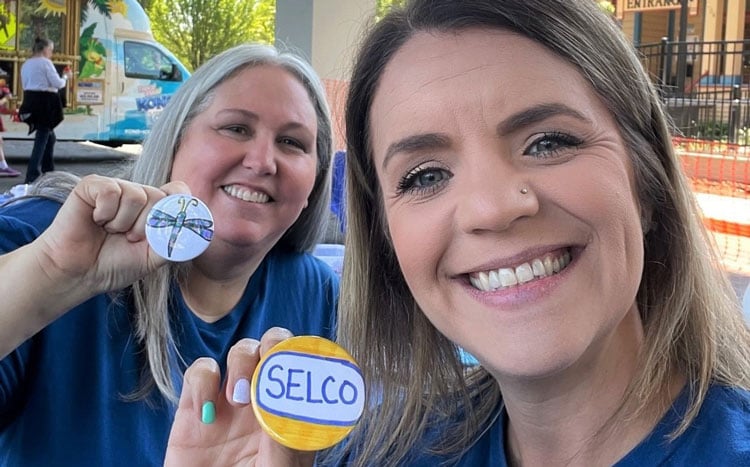 SELCO Community Credit Union employees holding up buttons