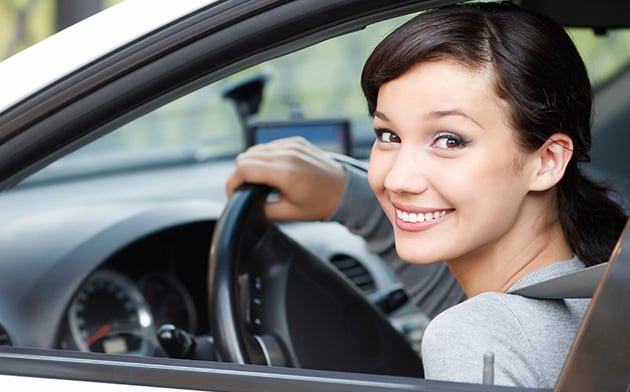 Young girl driving car with a smile
