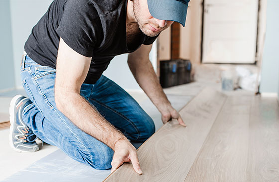 Person putting new hardwood floors in home