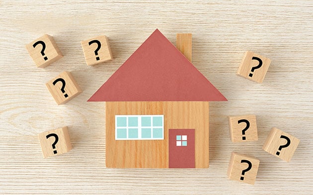 A house surrounded by blocks with question marks on them.