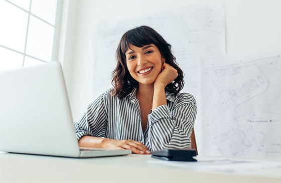 Women sitting at desktop computer smiling while working