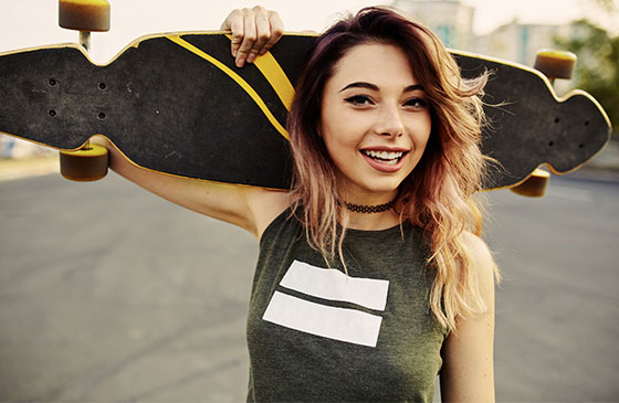 Teenage girl holding a skateboard 