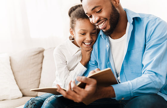 Man reads to his daughter.