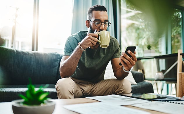 Man drinking coffee and looking at phone
