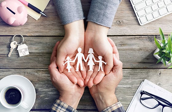 image of a cut out family being held in hands. 