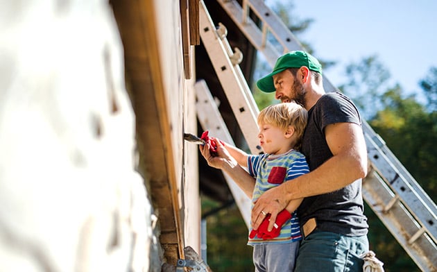 Man and boy painting house