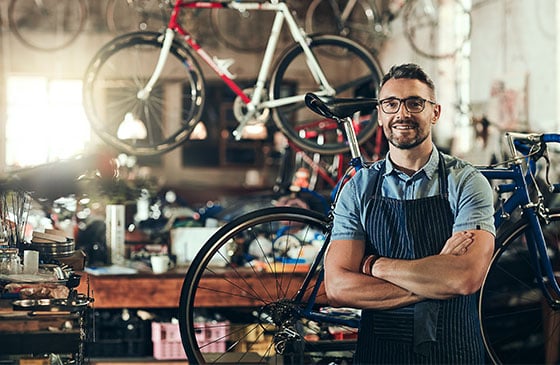 Bicycle shop owner standing with arms crossed