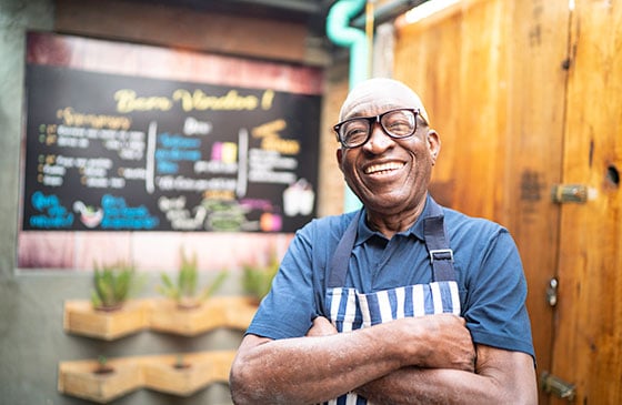 Man standing happy in front of his business