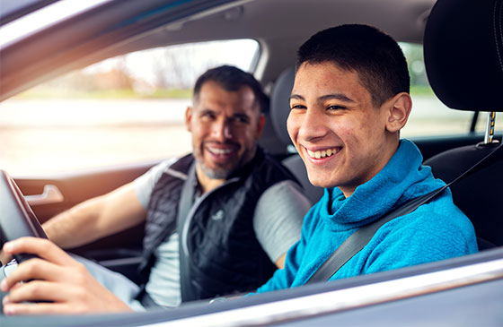 Father and son driving together in car