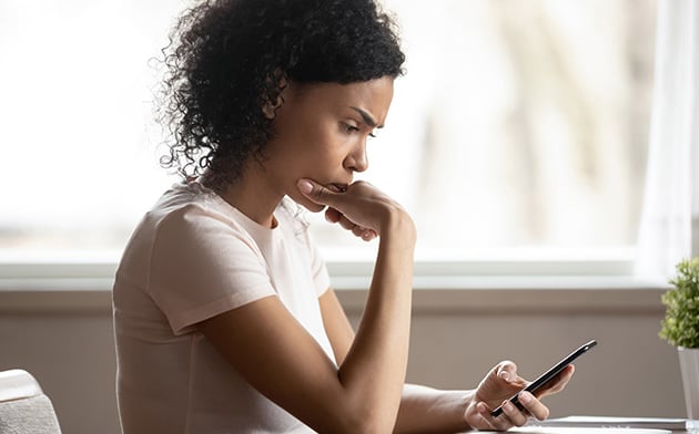 Concerned woman looks at phone