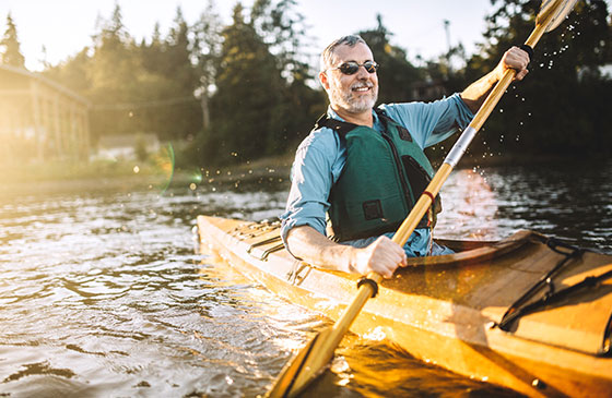 Man enjoying retirement life kayaking in lake