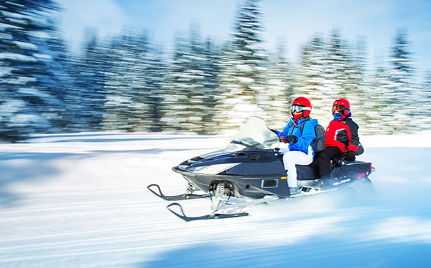 Two people on a snowmobile.