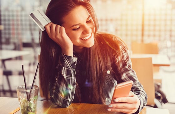 Younger person using phone to active credit card