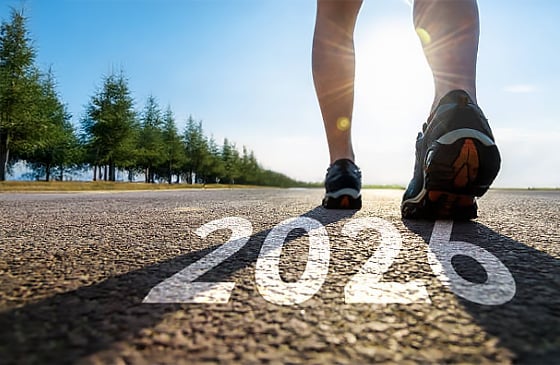 Person walking on a track that has 2026 written on it. 