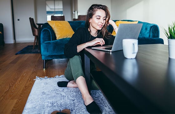 Young women sitting on floor working on computer