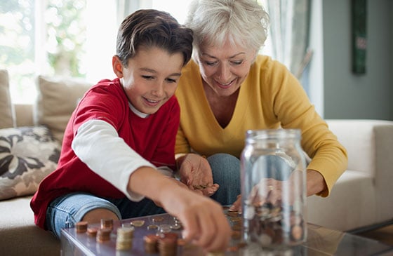 Woman and boy adding change to a jar