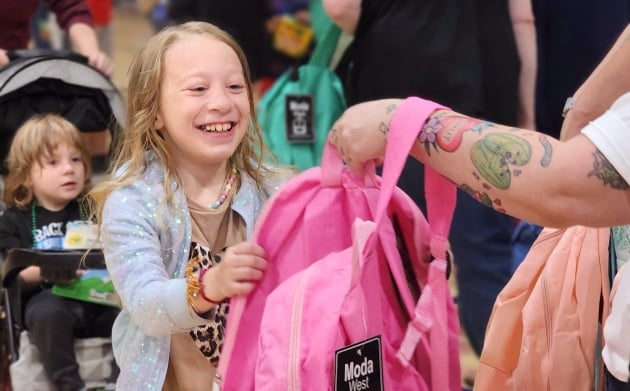 Little girl smiling and grabbing a pink
