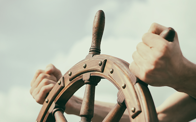 Hands on a ship's hand wheel