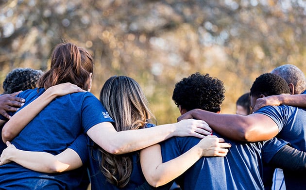 People with arms around each other