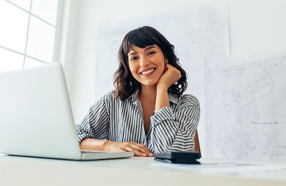 Woman sitting at her computer smiling.
