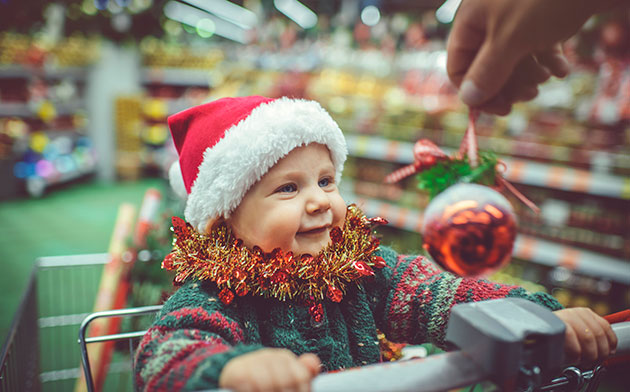 Baby smiles at Christmas ornament.