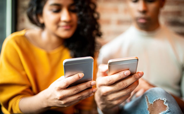 Two young people looking at phones