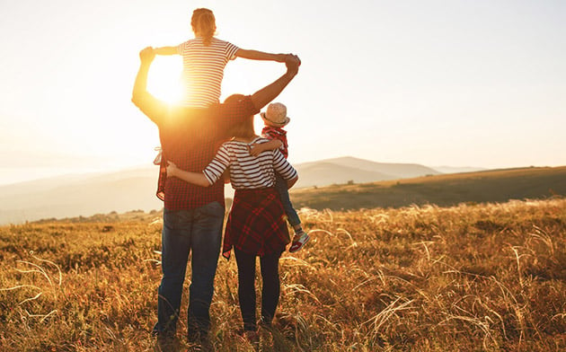 Family walking toward sunset