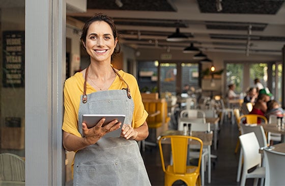 Female business owner standing in front of shop