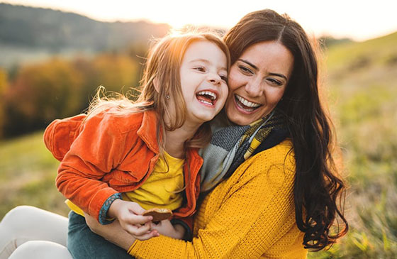 Mom and daughter laughing together outside