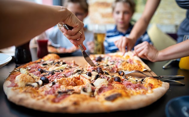 Hand cutting pizza