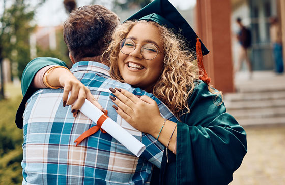 College graduate smiling with cap and gown on