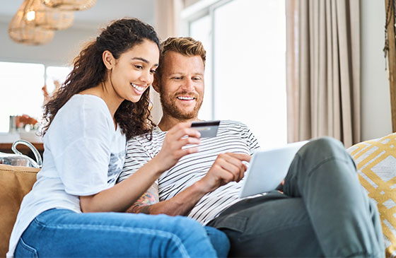 Couple sitting on the couch looking a educational content