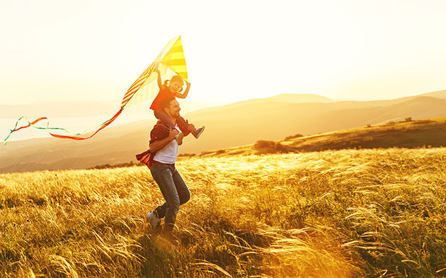 Father and son running through a field 